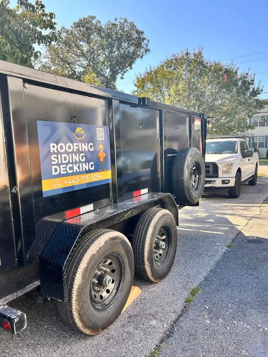 Trailer with a Home Restoration Group sign: roofing, siding and decking